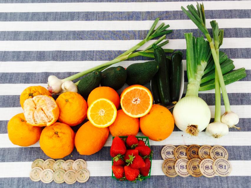 oranges strawberries onions and market match coins on striped tablecloth